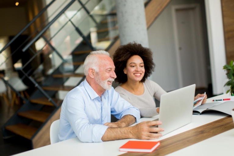 Senior businessman and young businesswoman working together in office